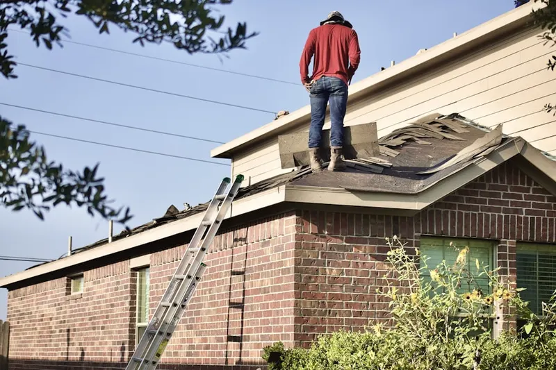 Professional roofer working on a residential roof in Daniels